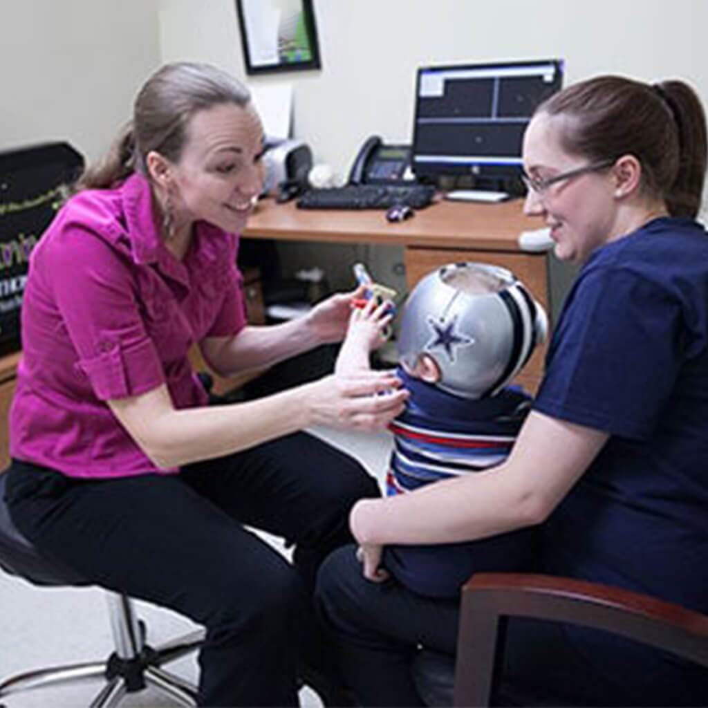 Pediatric orthotist providing expert cranial helmet guidance